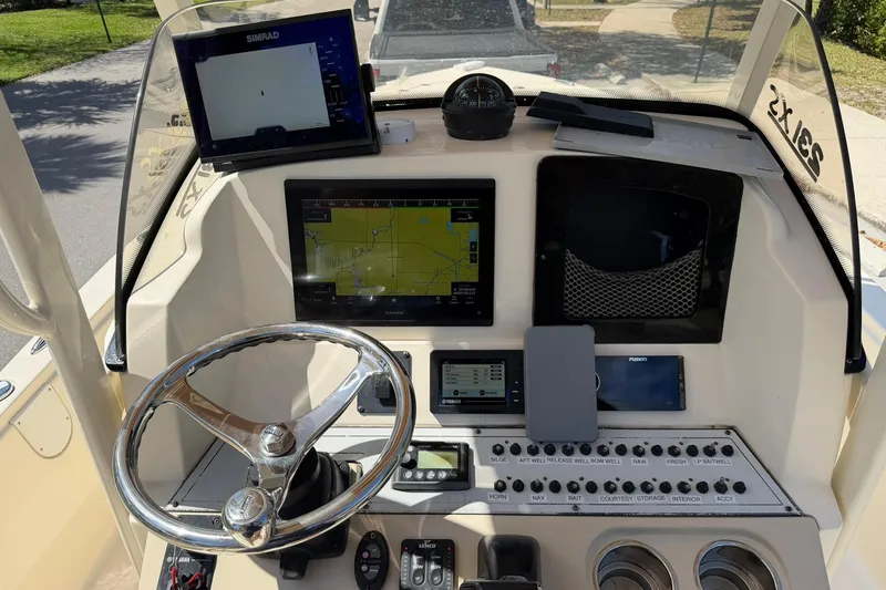 Slide: The Image of 2018 Scout 231 XS boat dashboard with navigation screens and controls. - 14