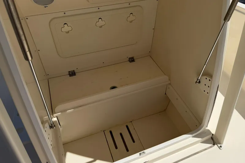 Slide: The Image of 2018 Scout 231 XS boat storage compartment with hinged lid and drainage. - 24