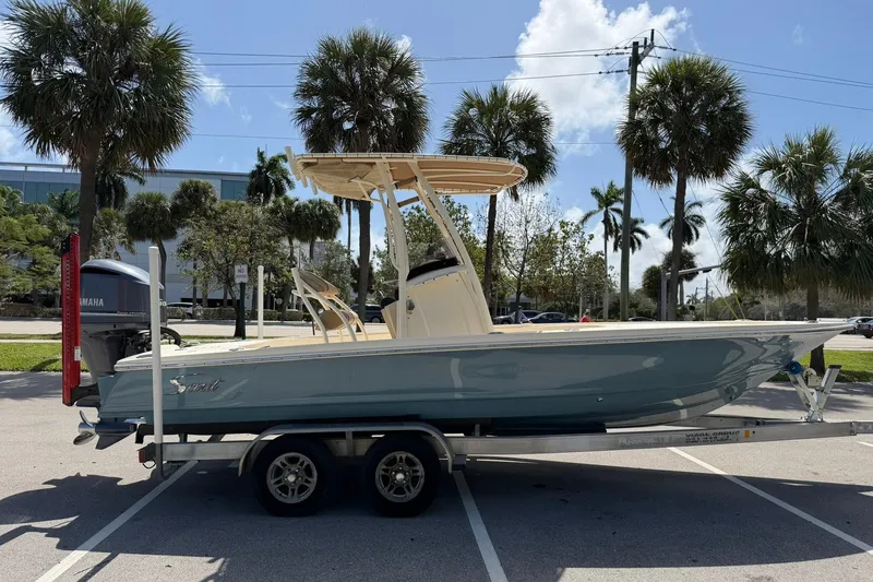 Slide: The Image of 2018 Scout 231 XS boat on trailer, parked under palm trees, with Yamaha outboard motor. - 6