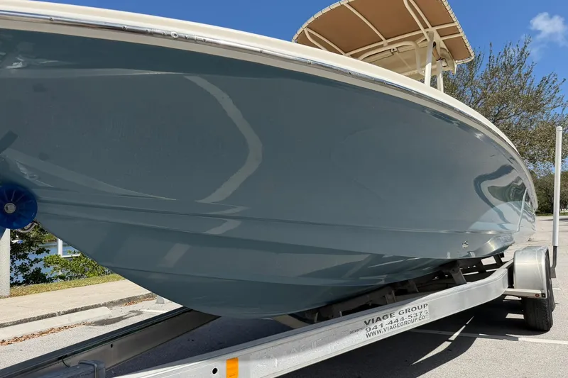 Slide: The Image of 2018 Scout 231 XS boat on trailer, side view under clear blue sky. - 9