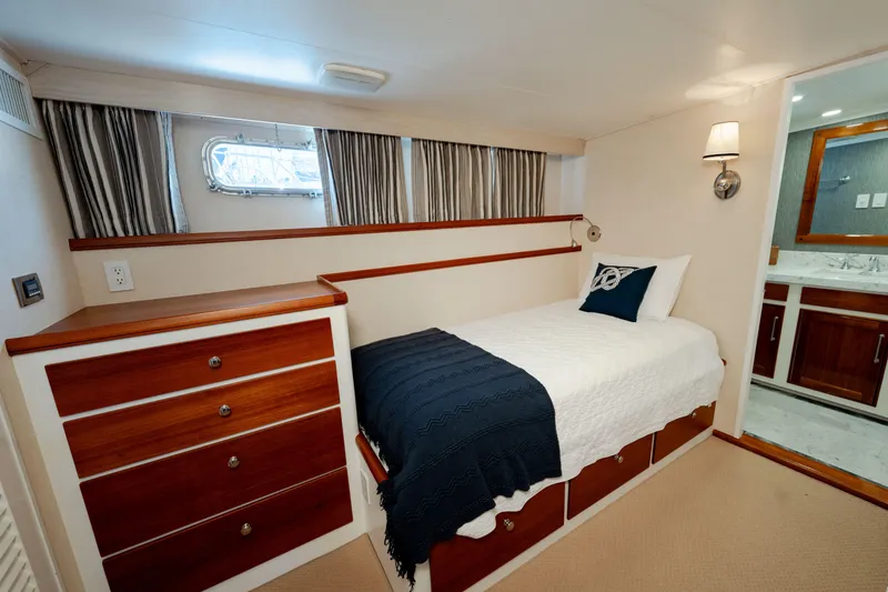 Slide: The Image of Cozy 1969 Custom Hargrave yacht cabin with single bed, wooden drawers, and ensuite bathroom. - 14