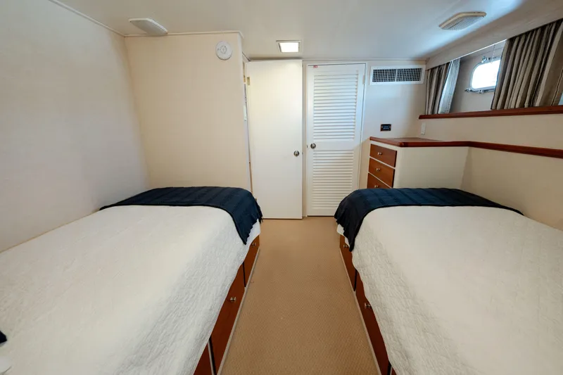 Slide: The Image of Twin cabin interior of 1969 Custom Hargrave yacht with white bedding and wood accents. - 19