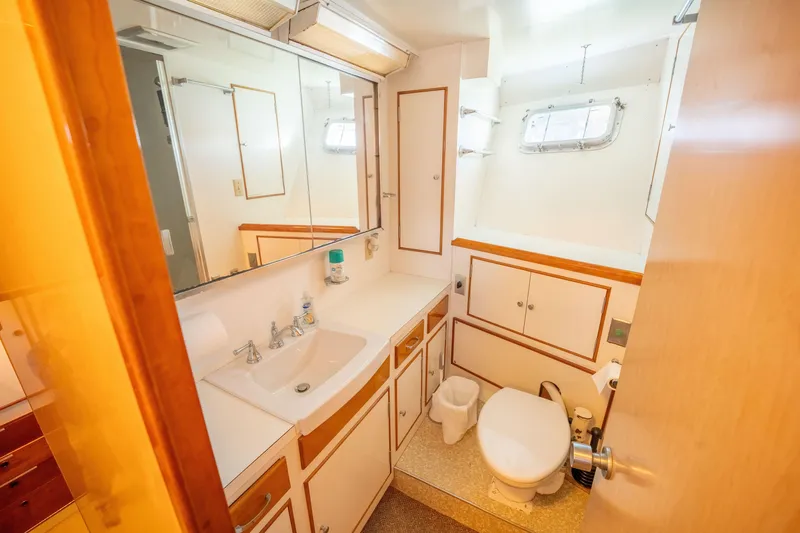 Slide: The Image of Vintage 1969 Custom Hargrave yacht bathroom with sink, toilet, and mirrored cabinets. - 22