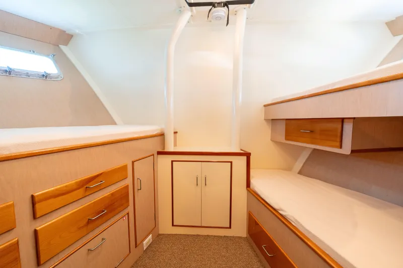 Slide: The Image of 1969 Custom Hargrave yacht cabin with wooden drawers, bunk beds, and a porthole window. - 24