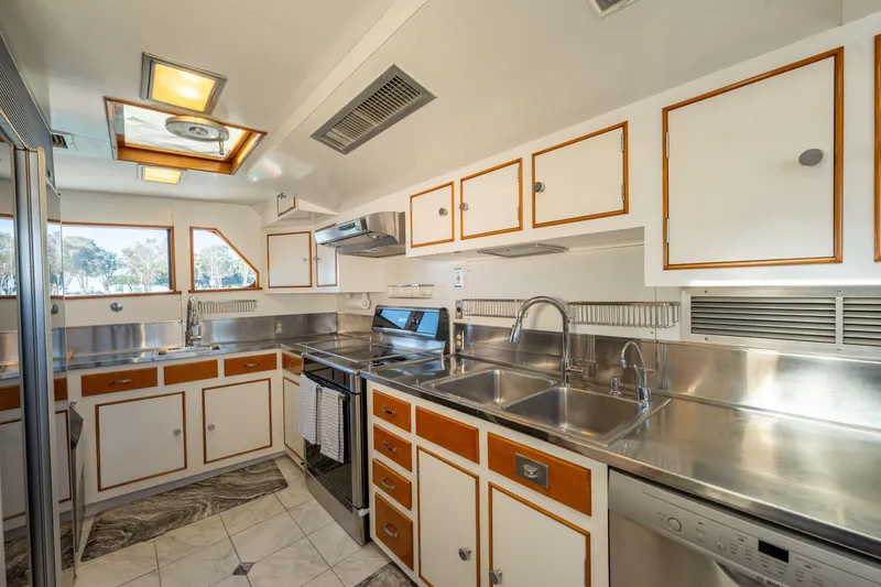 Slide: The Image of Vintage 1969 Custom Hargrave yacht kitchen with stainless steel counters and wooden cabinets. - 25