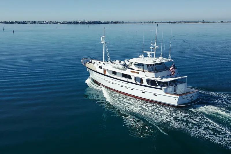 Slide: The Image of Custom 1969 Hargrave yacht cruising on calm blue waters, displaying American flag. - 37