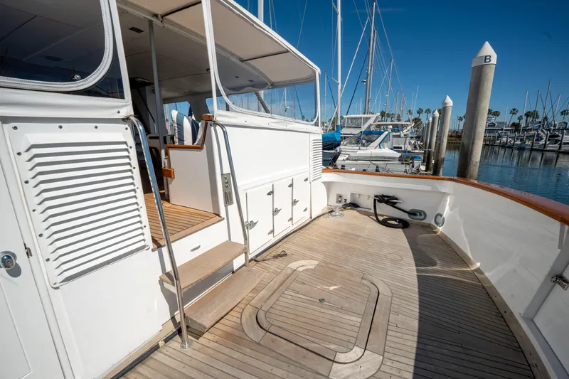 Slide: The Image of 1969 Custom Hargrave yacht deck with wooden flooring, docked at a marina under clear blue skies. - 40