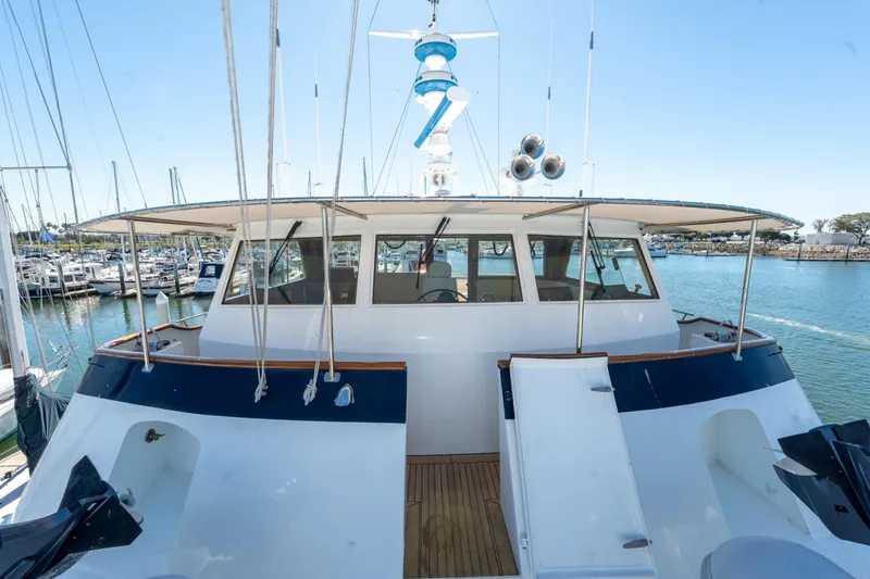 Slide: The Image of 1969 Custom Hargrave yacht docked in marina, showcasing helm and deck area. - 29