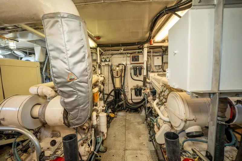 Slide: The Image of Engine room of a 1969 Custom Hargrave yacht, featuring complex machinery and piping. - 41
