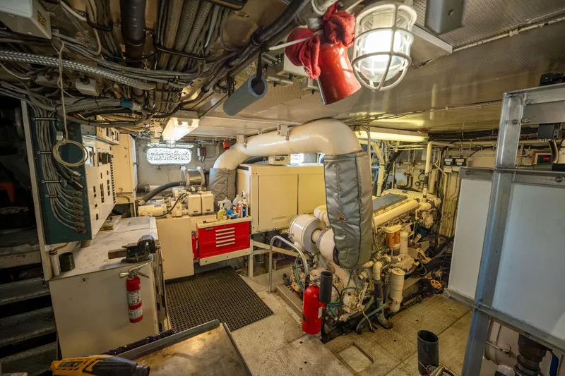 Slide: The Image of Engine room of a 1969 Custom Hargrave yacht, featuring machinery and control panels. - 43