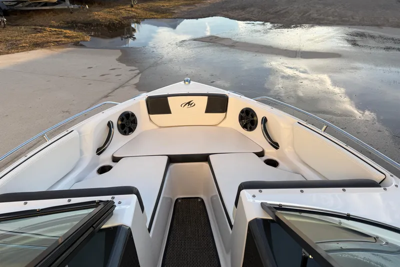 Slide: The Image of 2017 Monterey 196FS boat interior with white seating and speakers, docked near water. - 15