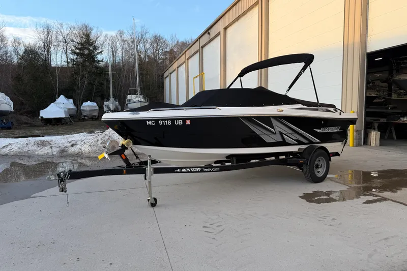 Slide: The Image of 2017 Monterey 196FS boat on trailer, parked outside a warehouse. - 2