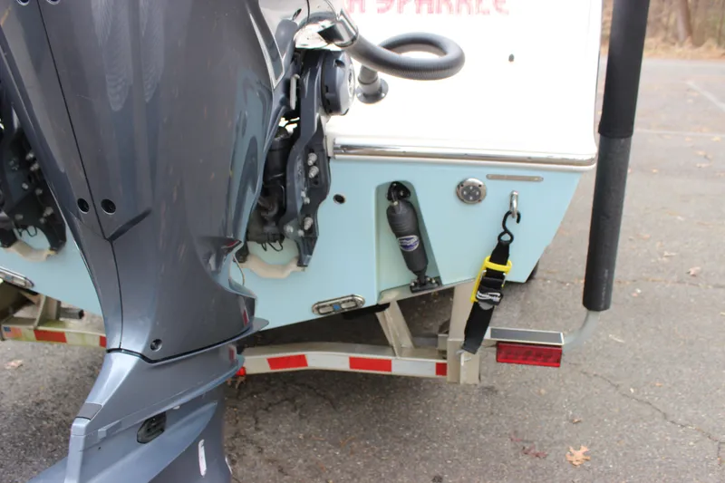 Slide: The Image of 2022 Cobia 280 Center Console boat on trailer, showing outboard motor and rear details. - 10