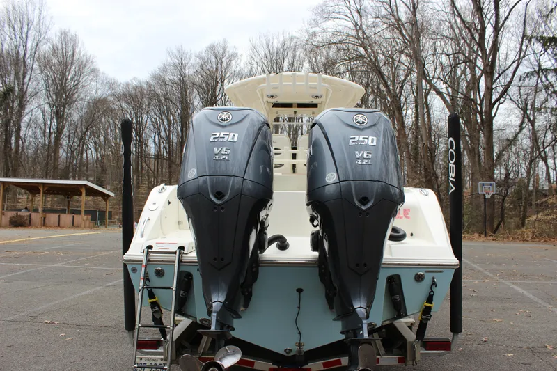 Slide: The Image of 2022 Cobia 280 Center Console with dual Yamaha 250 V6 engines in a wooded area. - 11