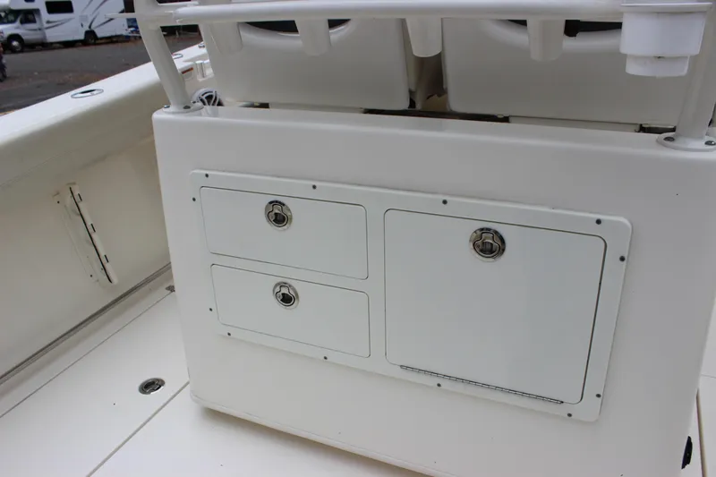 Slide: The Image of 2022 Cobia 280 Center Console boat storage compartments and seating area. - 25