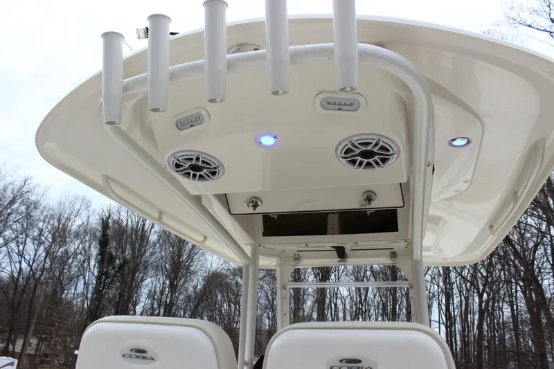 Slide: The Image of 2022 Cobia 280 Center Console boat with rod holders and speakers, viewed from below. - 27