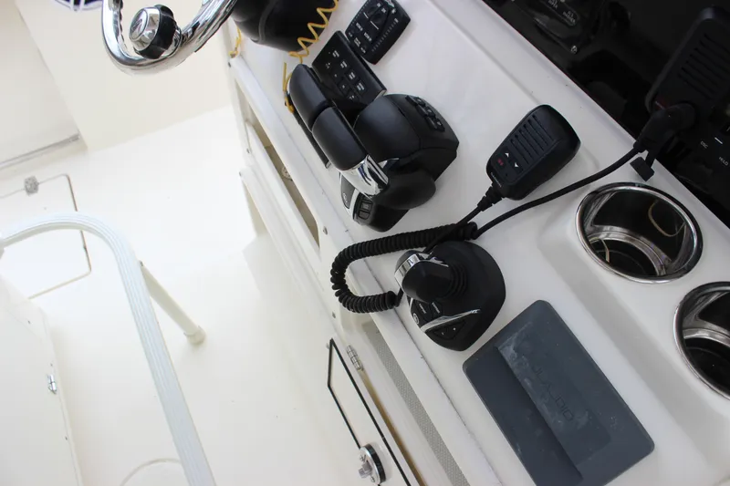 Slide: The Image of 2022 Cobia 280 Center Console helm with controls and steering wheel. - 29