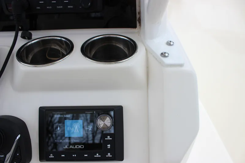 Slide: The Image of 2022 Cobia 280 Center Console dashboard with JL Audio system and cup holders. - 30
