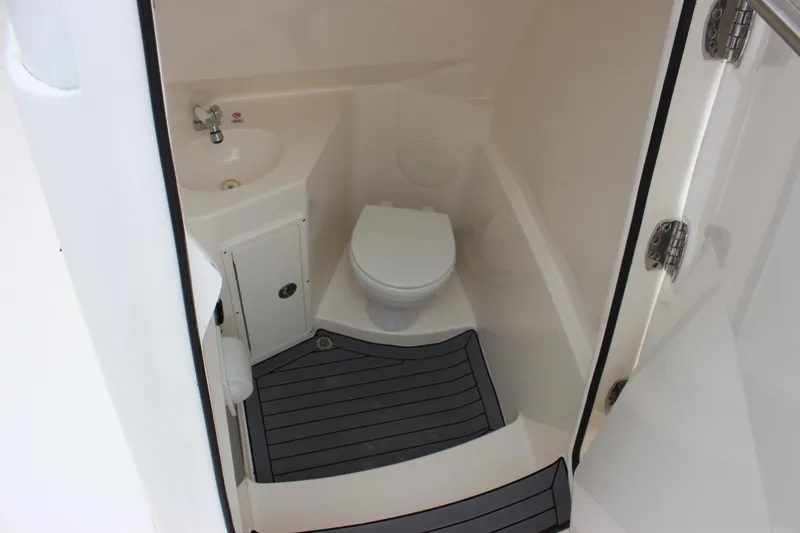 Slide: The Image of 2022 Cobia 280 Center Console boat bathroom with sink and toilet. - 38