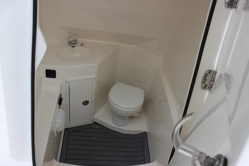 Slide: The Image of 2022 Cobia 280 Center Console boat interior bathroom with sink and toilet. - 40