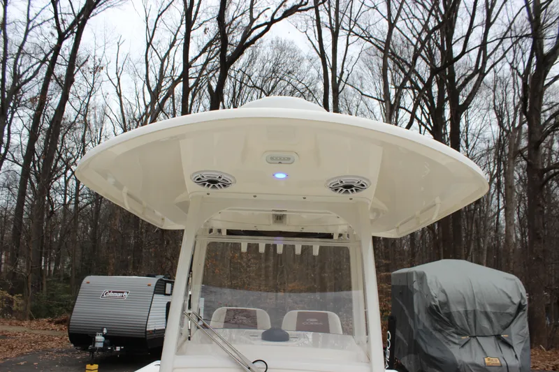 Slide: The Image of 2022 Cobia 280 Center Console boat with T-top in wooded area. - 48
