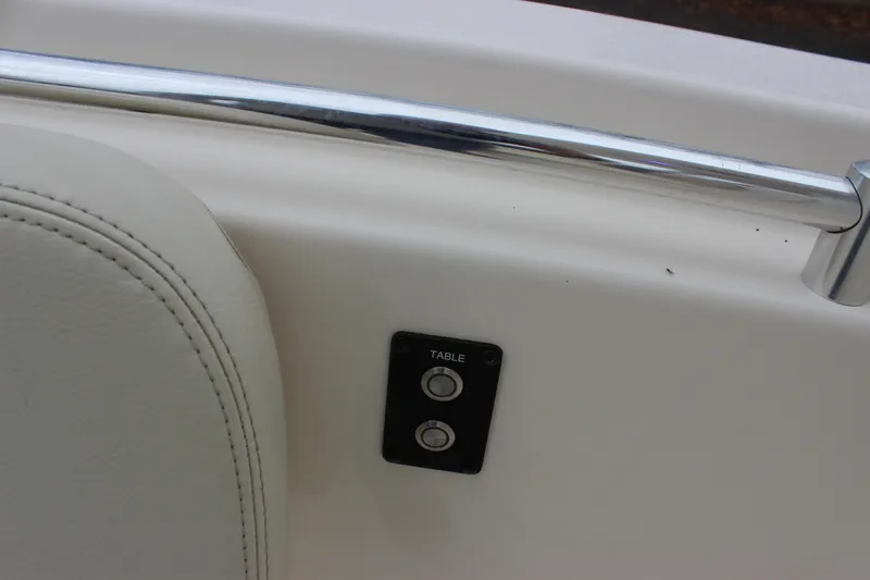 Slide: The Image of 2022 Cobia 280 Center Console boat interior with table control buttons and railing. - 50