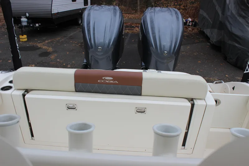 Slide: The Image of 2022 Cobia 280 Center Console boat with dual engines and rod holders. - 61