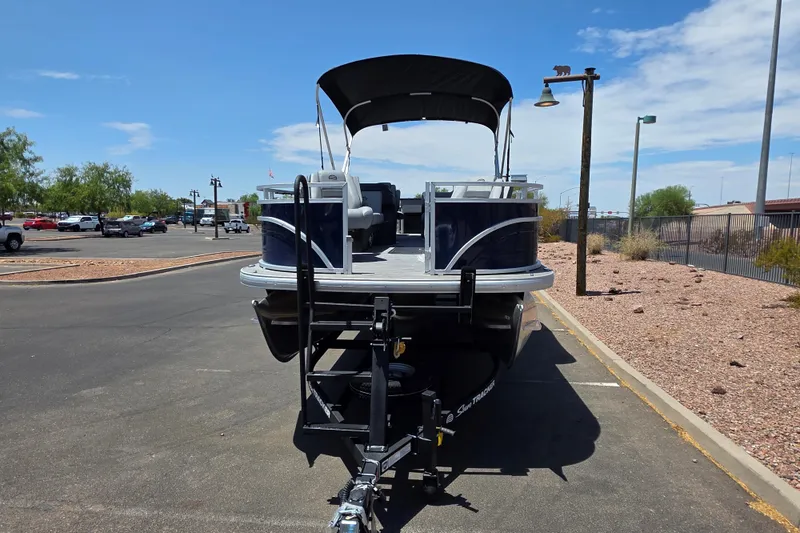 Slide: The Image of 2026 Sun Tracker Sportfish 24 XP3 pontoon boat on trailer in parking lot. - 2
