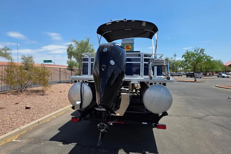 Slide: The Image of 2026 Sun Tracker Sportfish 24 XP3 pontoon boat with outboard motor in a parking lot. - 3