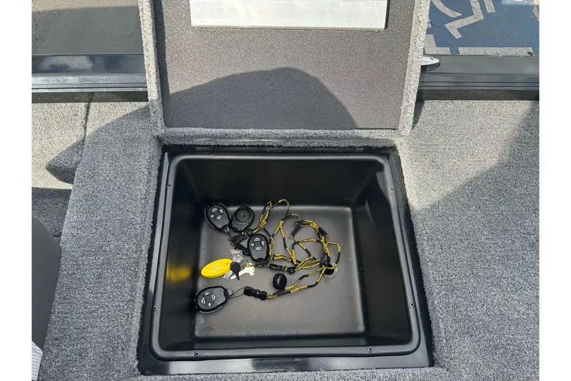 Slide: The Image of Open storage compartment in 2026 Ranger ALPHA 208 boat with key fobs inside. - 94