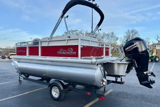 Slide: The Image of 2026 Sun Tracker Bass Buggy 16 XL Select pontoon boat with Mercury outboard motor in parking lot. - 101