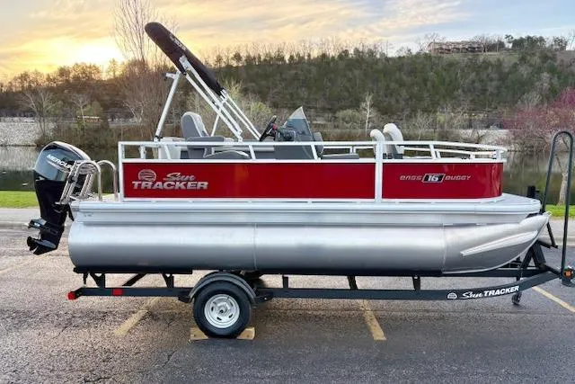 Slide: The Image of 2026 Sun Tracker Bass Buggy 16 XL Select pontoon boat on trailer at sunset. - 114