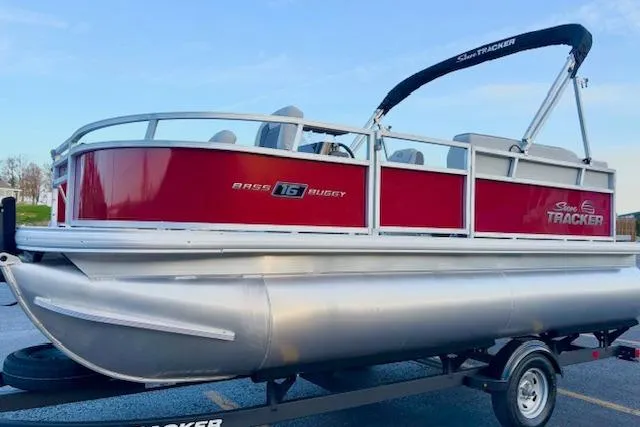 Slide: The Image of 2026 Sun Tracker Bass Buggy 16 XL Select pontoon boat on trailer, red and silver design. - 116