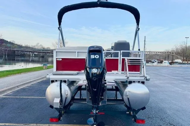 Slide: The Image of 2026 Sun Tracker Bass Buggy 16 XL Select pontoon boat with 50 HP motor, parked by a lake. - 98