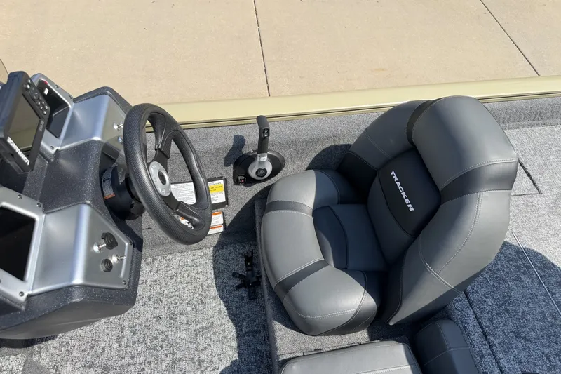 Slide: The Image of 2026 Tracker Pro Team 175 boat interior with steering wheel and cushioned seat. - 18