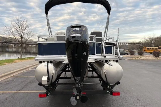 Slide: The Image of 2026 Sun Tracker Bass Buggy 18 DLX pontoon boat with 75 HP engine, parked near a lake. - 99