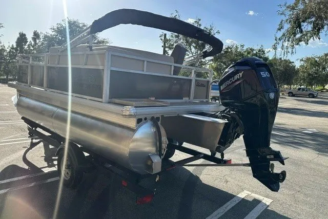 Slide: The Image of 2026 Sun Tracker Bass Buggy 16 XL Select pontoon boat with Mercury 50 engine in parking lot. - 12