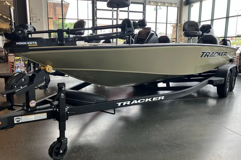 Slide: The Image of 2026 Tracker Savage 215 boat on trailer in showroom, featuring Minn Kota Maxxum motor. - 2