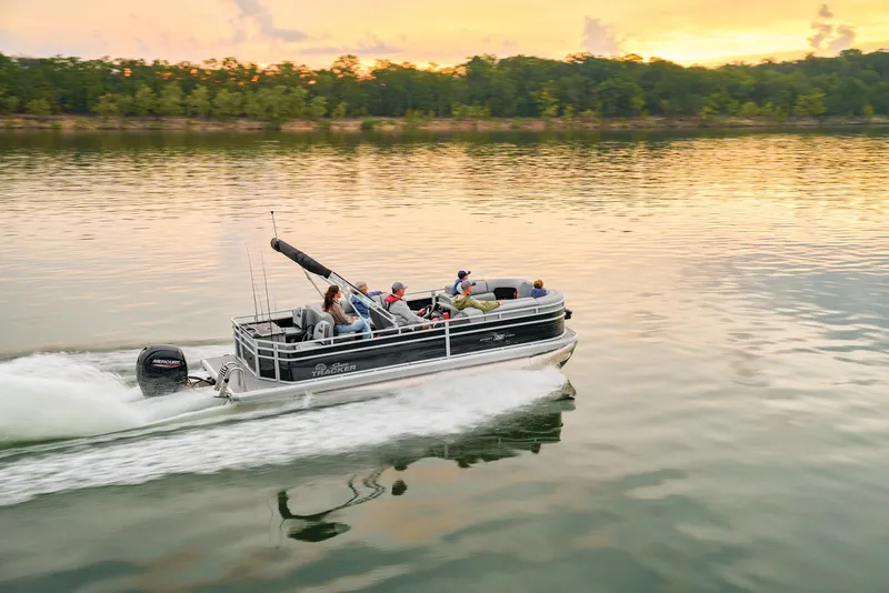 Slide: The Image of 2026 Sun Tracker SportFish 22 DLX pontoon boat on trailer, parked outdoors. - 2