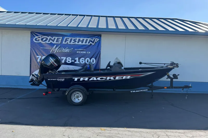 The Image of 2026 Tracker Super Guide V-16 SC boat on trailer outside marine shop. - 1