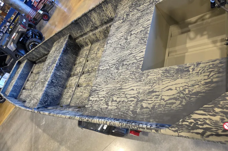 Slide: The Image of 2026 Tracker Grizzly 15 Jon boat with camouflage pattern in showroom. - 20