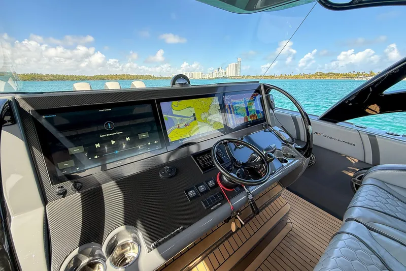Slide: The Image of 2023 Midnight Express 43 Solstice helm with advanced navigation screens and luxurious seating. - 28