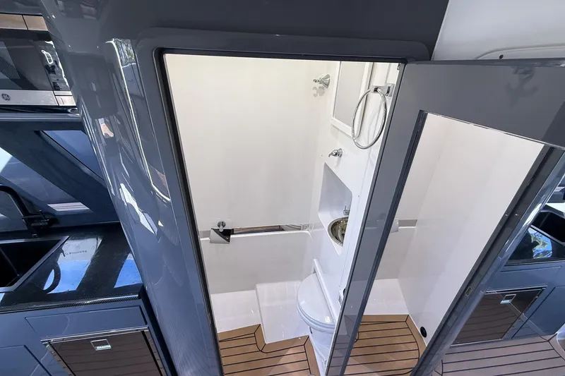 Slide: The Image of 2023 Midnight Express 43 Solstice interior bathroom with modern fixtures and wooden flooring. - 42