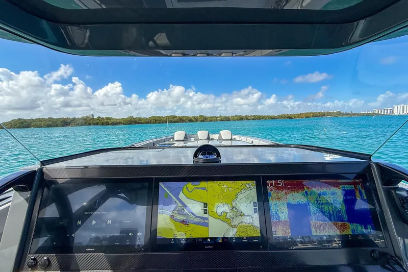 Slide: The Image of Cockpit view of 2023 Midnight Express 43 Solstice boat with navigation screens, on blue water. - 52