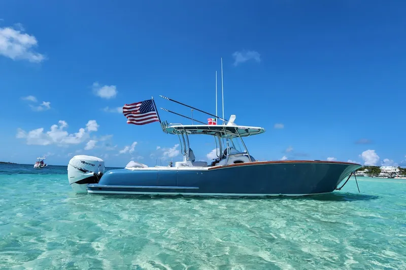The Image of 2019 Mag Bay 33 CC boat in clear turquoise water, flying an American flag. - 0