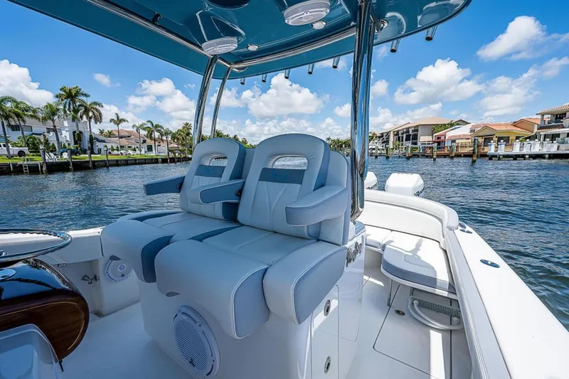 Slide: The Image of 2019 Mag Bay 33 CC boat interior with luxurious seating, set against a waterfront backdrop. - 11