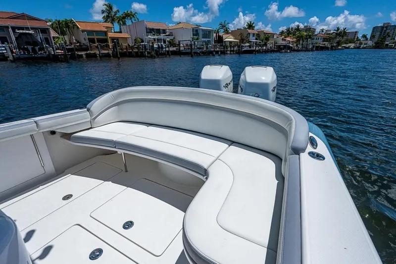 Slide: The Image of 2019 Mag Bay 33 CC boat with white seating, docked near waterfront homes. - 13