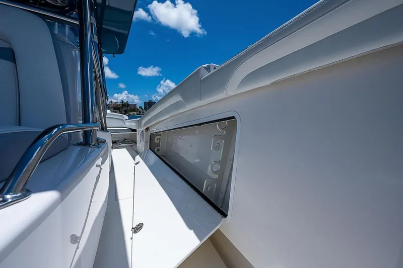 Slide: The Image of 2019 Mag Bay 33 CC boat interior with open storage compartment under clear blue sky. - 15