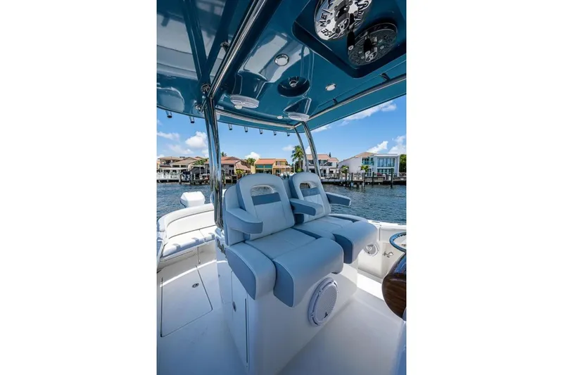 Slide: The Image of 2019 Mag Bay 33 CC boat interior with blue seating and waterfront view. - 16