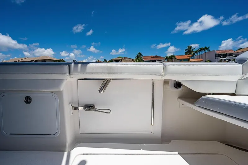 Slide: The Image of 2019 Mag Bay 33 CC boat interior with white seating and storage compartments. - 18